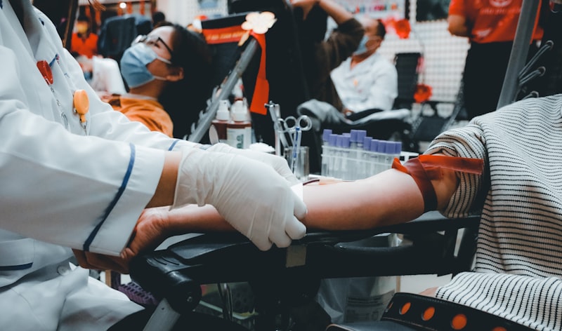 Licensed nurse drawing a blood sample from a patient's arm at home